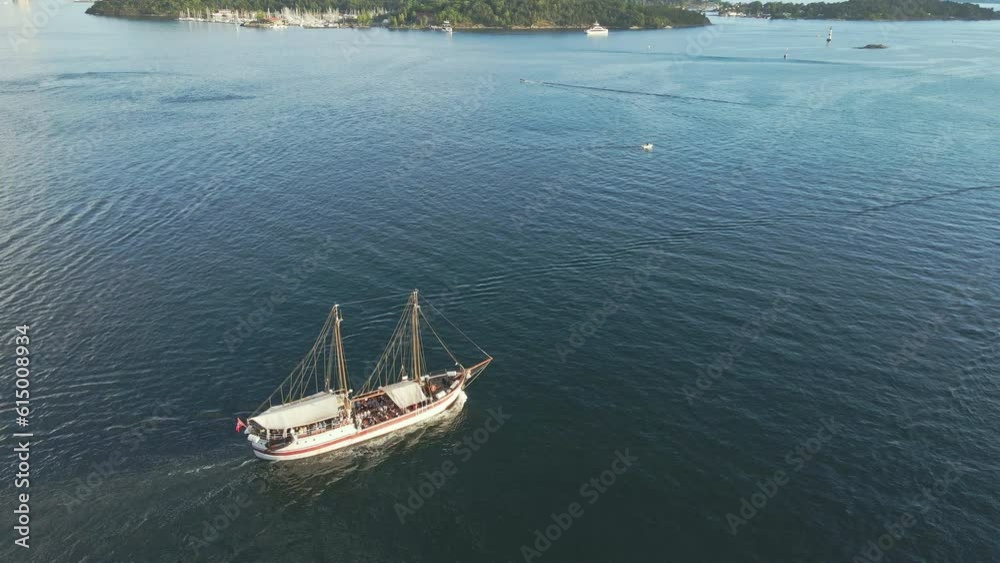 A sailboat and other vessels head out into open waters in Oslo Norway A sailboat and other vessels head out into open waters in Oslo Norway