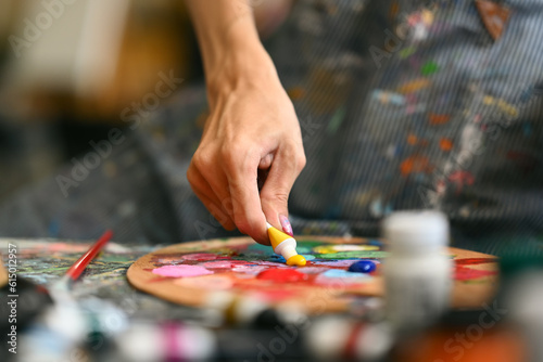 Closeup view of male artist mixing color oil painting on palette. Art, hobby and leisure activity concept