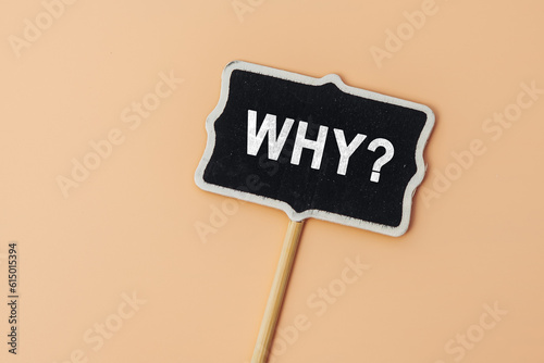 Why - word on a small chalkboard on a beige background. Top view. Business answer and analysis, problem ask, interrogation, research information concept