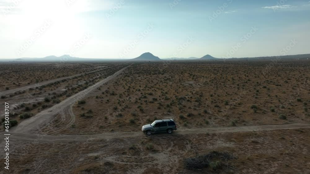 Off road vehicle navigating the Mojave Desert terrain - aerial Off road vehicle navigating the Mojave Desert terrain - aerial