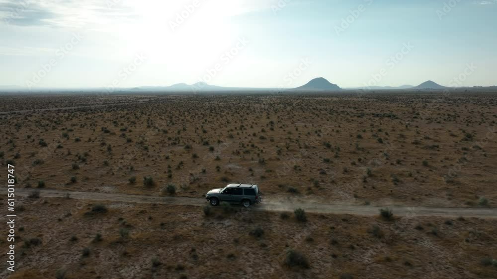 Sport utility vehicle driving along an off-road trail in the Mojave Desert - aerial Sport utility vehicle driving along an off-road trail in the Mojave Desert - aerial