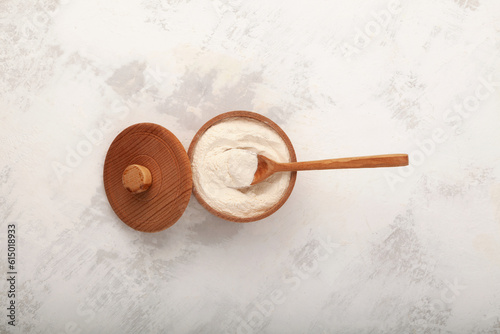 Xanthan Gum Powder in wooden bowl with spoon, top view. Food additive E415. Texture improver. Stabiliser. Natural Thickener gluten-free food. Used in cosmetic, and food industry as binding agen