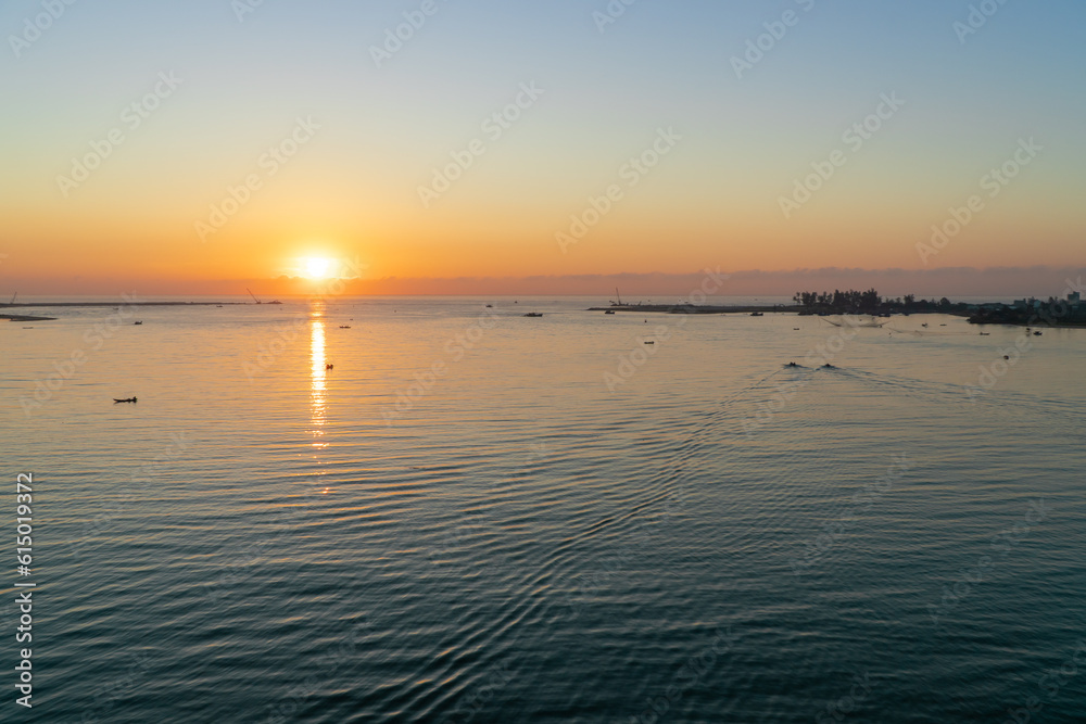 Landscape at the mouth of the river at dawn with small fishing boats in the distance.  Taken from above.