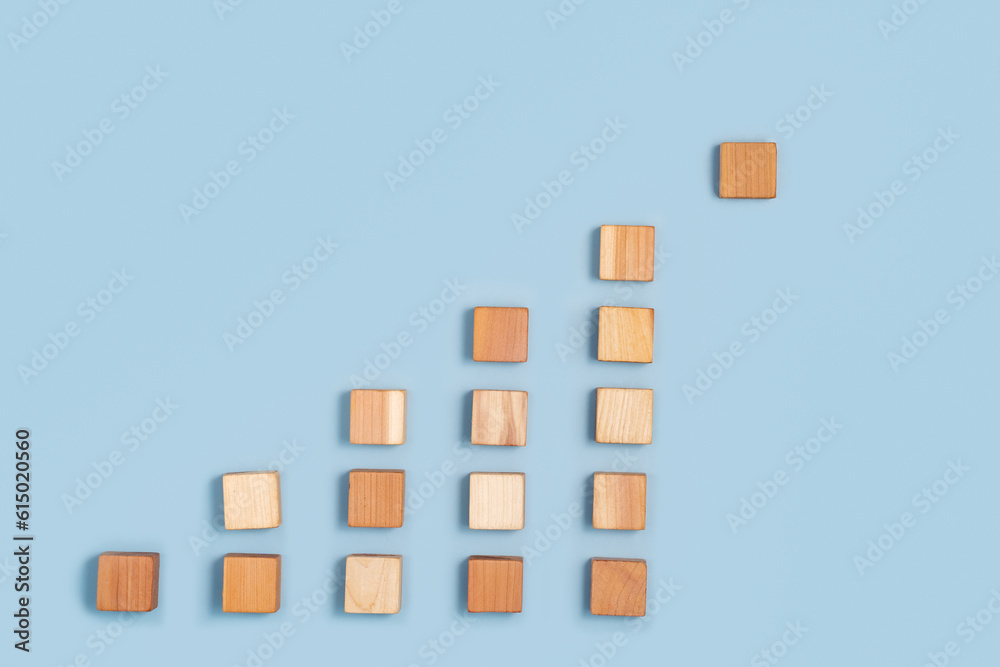blank wooden cubes in a pyramid shades ranging from dark to light beige on blue background. Minimalistic abstract concept representation of progress and diversity. Top view flat lay copy space blank wooden cubes in a pyramid shades ranging from dark to light beige on blue background. Minimalistic abstract concept representation of progress and diversity. Top view flat lay copy space