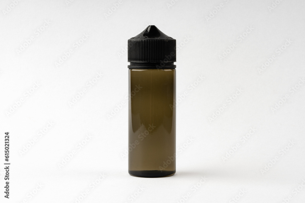 Small black glass dropper bottle front view on gray background Small black glass dropper bottle front view on gray background