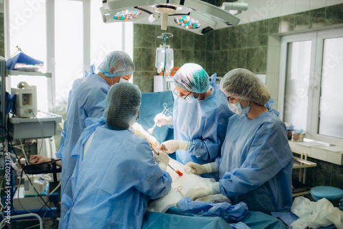 Surgical team performing surgery operation. Doctor performing surgery using sterilized equipment. Gynecologists and midwifes giving birth. Infant in maternity hospital
