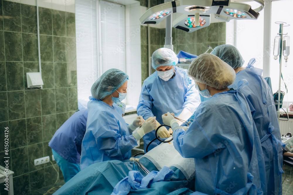 surgeons perfoming surgery operation of abdominal cesarean section during child delivery birth at clinic operating room. surgeons perfoming surgery operation of abdominal cesarean section during child delivery birth at clinic operating room.