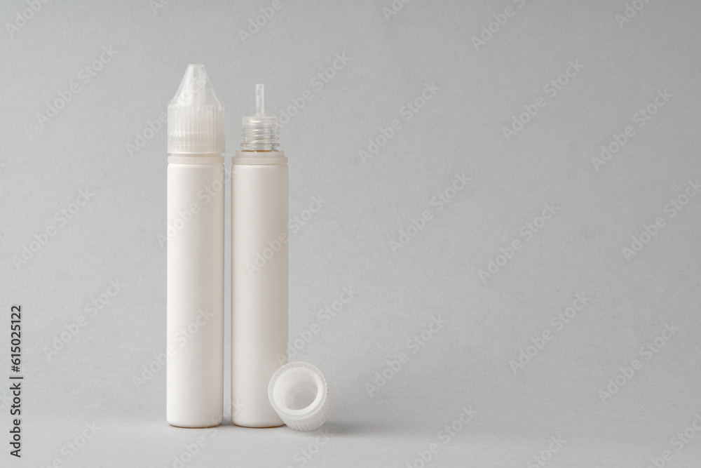 Refill liquid for electronic cigarettes on gray background Refill liquid for electronic cigarettes on gray background