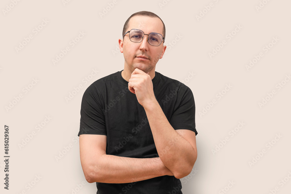 Portrait of a young man looking at the camera on a beige background. Portrait of a young man looking at the camera on a beige background.