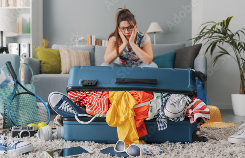 Stressed woman packing for a vacation photo