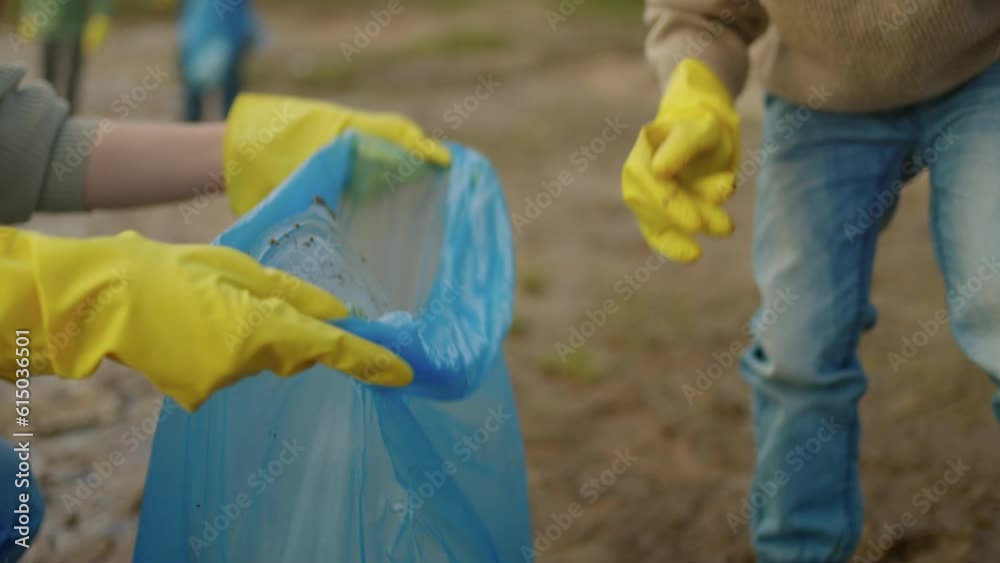 Volunteers Family Cleaning Shore Of Lake From Plastic Waste, Little Daughter Helping To Her Mother Volunteers Family Cleaning Shore Of Lake From Plastic Waste, Little Daughter Helping To Her Mother