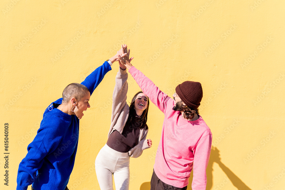 joyful young people high fives and having fun together on yellow background, concept of friendship and happiness, copy space for text - obrazy, fototapety, plakaty 