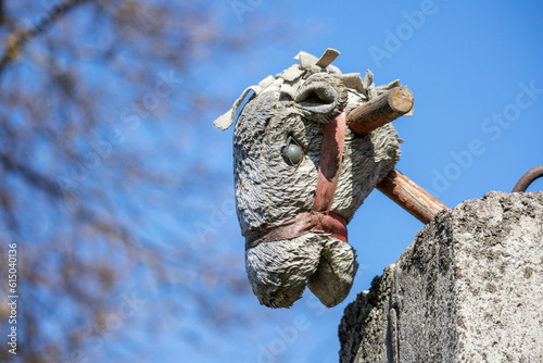  A horse's head toy on a wooden stick over a concrete fence against a blue sky