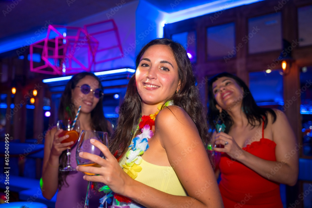 Portrait attractive woman smiling with a glass of alcohol in a nightclub at a night party Portrait attractive woman smiling with a glass of alcohol in a nightclub at a night party