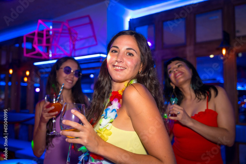 Portrait attractive woman smiling with a glass of alcohol in a nightclub at a night party