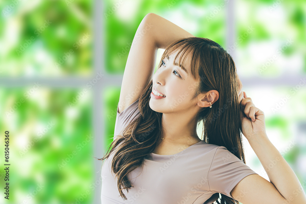 窓のある部屋でストレッチをする日本人女性