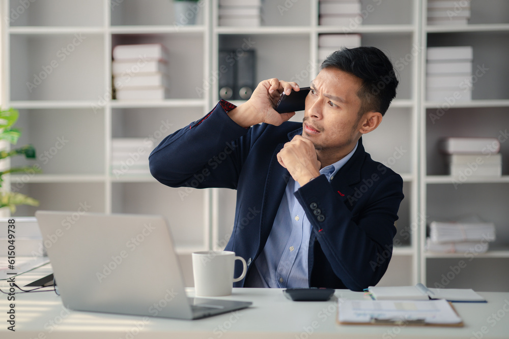 Man working in office and talking on the phone, he is young businessman, modern business management, start-up company run by young people, modern entrepreneur with new ideas. to be a business leader. Man working in office and talking on the phone, he is young businessman, modern business management, start-up company run by young people, modern entrepreneur with new ideas. to be a business leader.