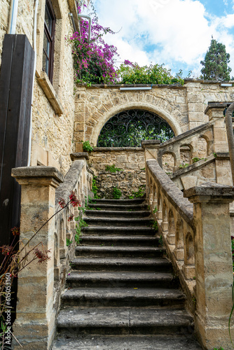 Selective focus on beautiful stone staircase with arched side walls, greenery and flowers in the old town of Kyrenia or Girne, Northern Cyprus.