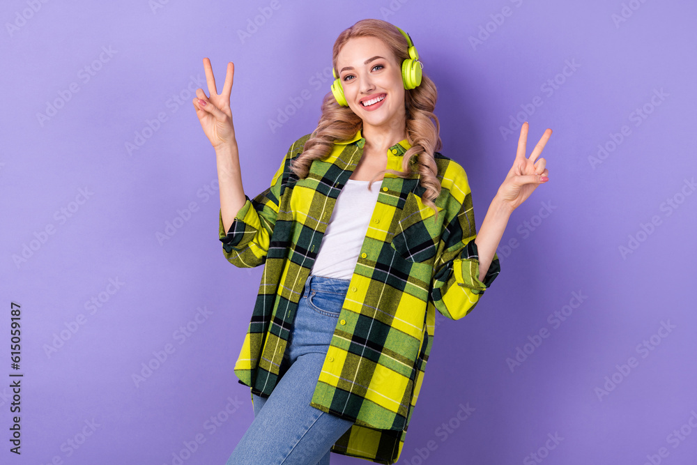 Photo of cute cheerful lady hands fingers demonstrate v-sign listen favorite playlist headphones isolated on violet color background Photo of cute cheerful lady hands fingers demonstrate v-sign listen favorite playlist headphones isolated on violet color background
