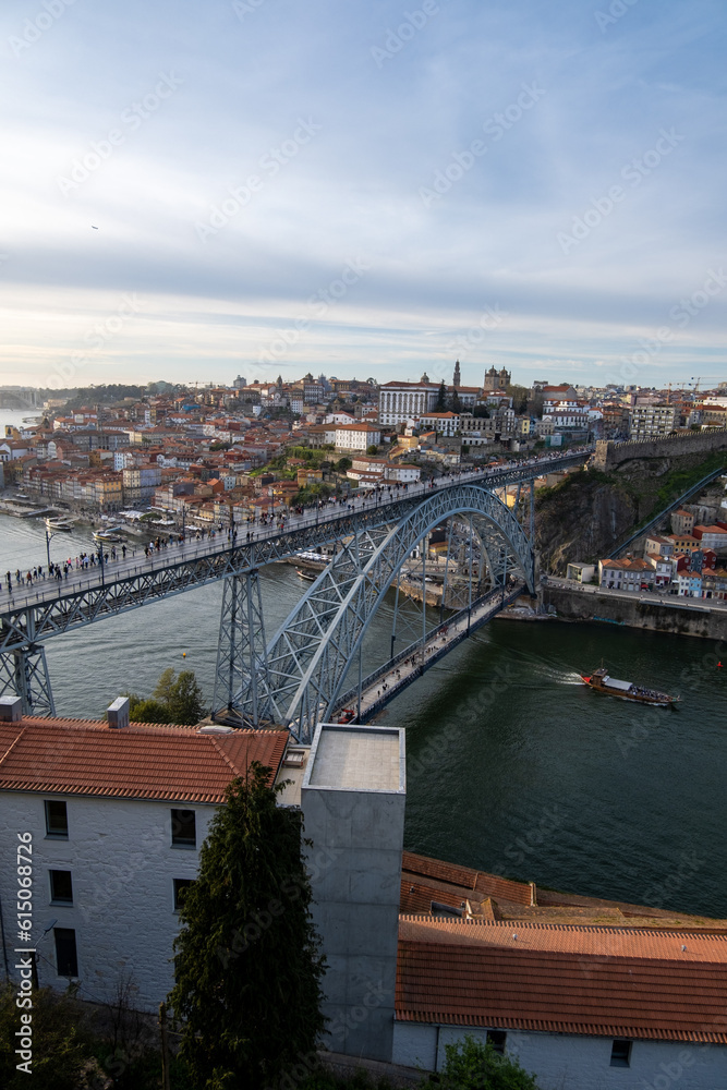 La belleza de Oporto, Portugal, con el emblemático puente de Don Luis como protagonista. En la imagen, el puente de hierro se extiende majestuosamente sobre el río Duero, conectando las dos orillas de