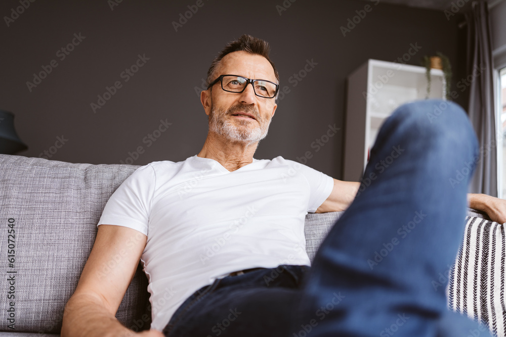 Older Man Sitting Relaxingly on His Sofa, Gazing into the Future Older Man Sitting Relaxingly on His Sofa, Gazing into the Future
