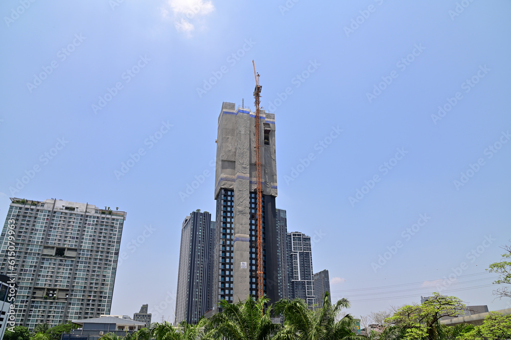 Fototapeta premium BANGKOK, THAILAND - June 20, 2023 : The construction of new building in the city with blue sky background in the city. Construction Concept in Thailand.