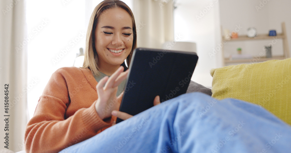 Woman, home and tablet on home sofa with internet connection for streaming video or movie online. Asian female happy, relax and laughing or scrolling on social media or mobile app for communication Woman, home and tablet on home sofa with internet connection for streaming video or movie online. Asian female happy, relax and laughing or scrolling on social media or mobile app for communication