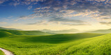 natural panoramic summer landscape, beautiful green fields in the hilly area in the early morning with blue sky and clouds. AI generated.