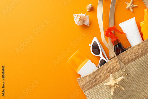Safe suntan on vacation concept. Top view photo of sunglasses and sunscreen bottles in wicker bag with marine shells around on orange isolated background with copyspace