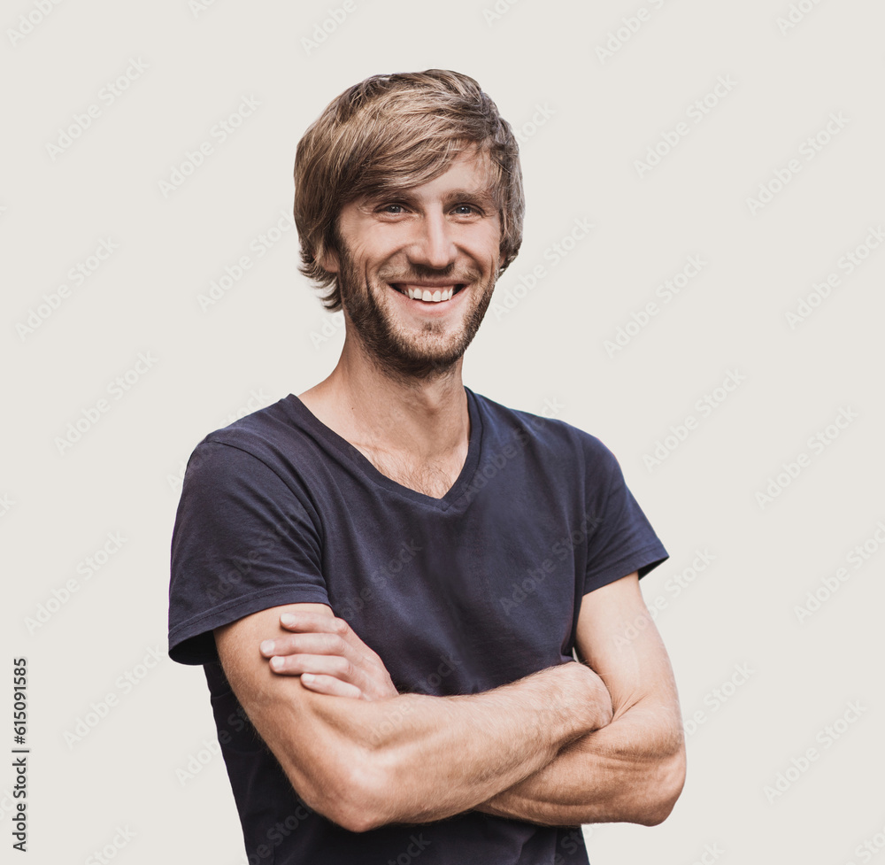 Obraz premium Portrait of handsome smiling young man with folded arms. Smiling joyful cheerful men with crossed hands studio shot. Isolated on gray background