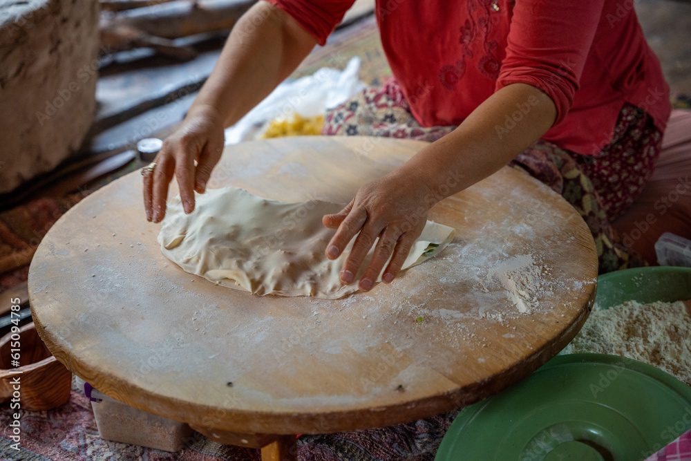 Hands of Turkish cook preparing potato and cheese gozleme on wooden table. Traditional stuffed pancakes in Alanya, Turkey Hands of Turkish cook preparing potato and cheese gozleme on wooden table. Traditional stuffed pancakes in Alanya, Turkey