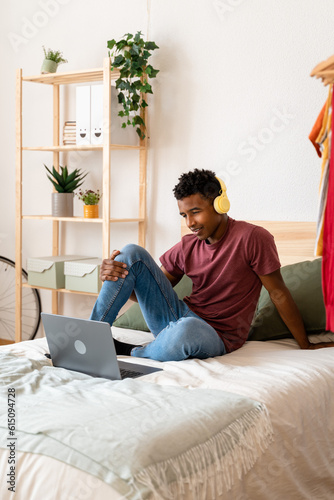 Young man using laptop while watching movies.