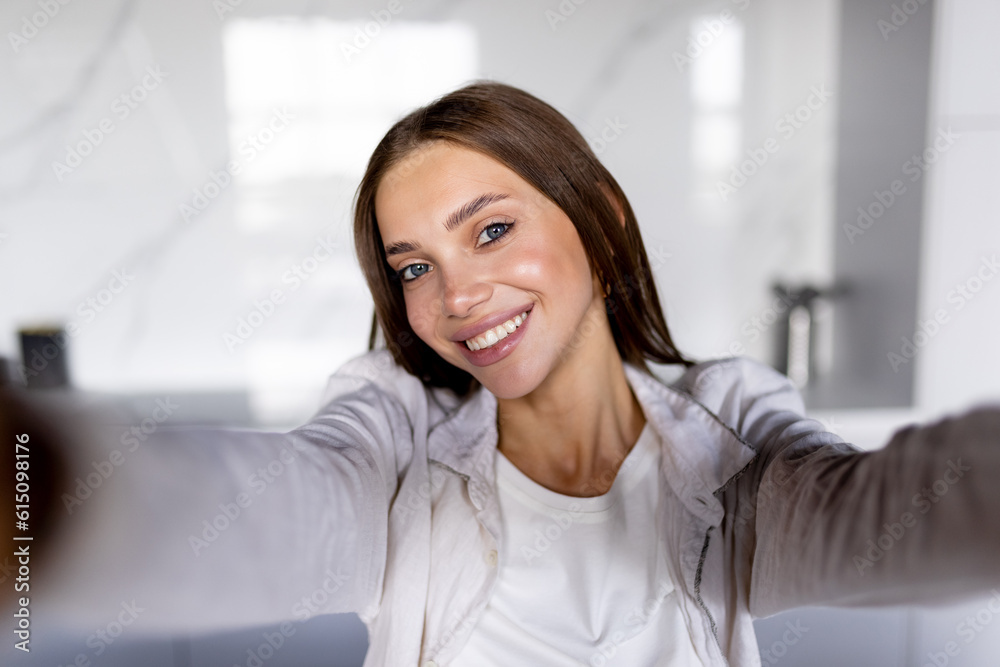 Self portrait of charming woman in shirt shooting selfie on front camera having video call with her lover Self portrait of charming woman in shirt shooting selfie on front camera having video call with her lover