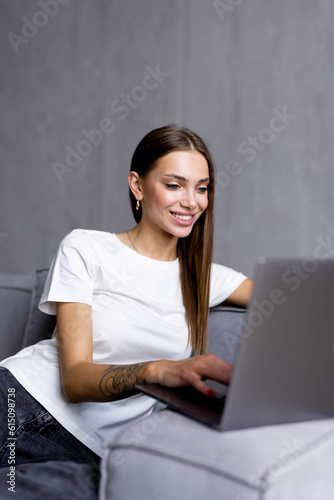 Happy pretty woman using laptop sitting on sofa © F8  \ Suport Ukraine