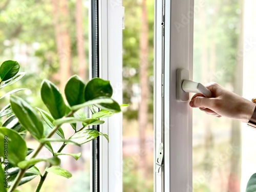 To open a window with a mosquito net. Plastic Windows with sunlight background.