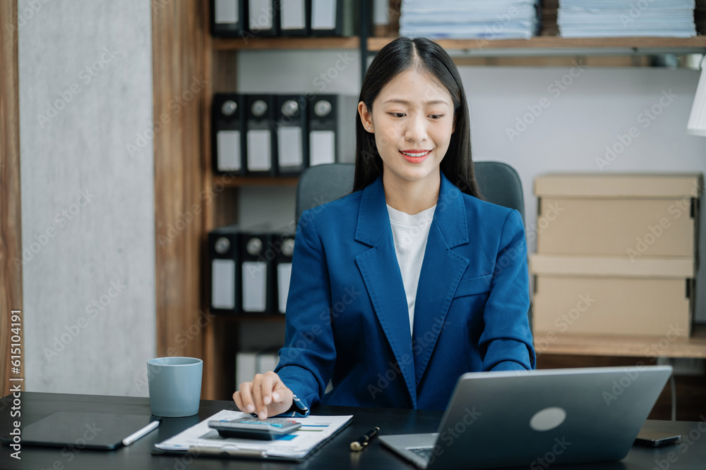 Business woman working on laptop and accounting financial report, accountant using calculator to calculate tax refund at office. Business woman working on laptop and accounting financial report, accountant using calculator to calculate tax refund at office.