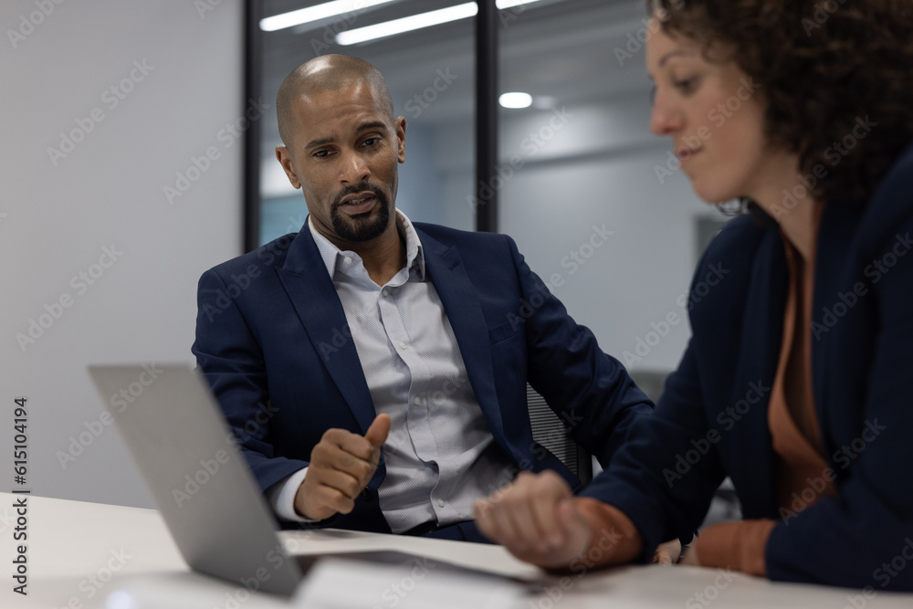 Businessman working late in an office with a colleague on a deadline Businessman working late in an office with a colleague on a deadline