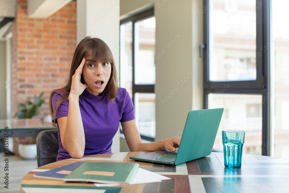 young pretty woman looking happy, astonished and surprised. universitary student with a laptop young pretty woman looking happy, astonished and surprised. universitary student with a laptop