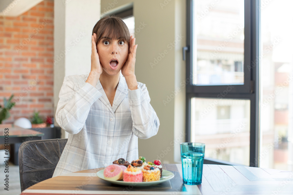 young pretty woman feeling extremely shocked and surprised. home made cakes concept