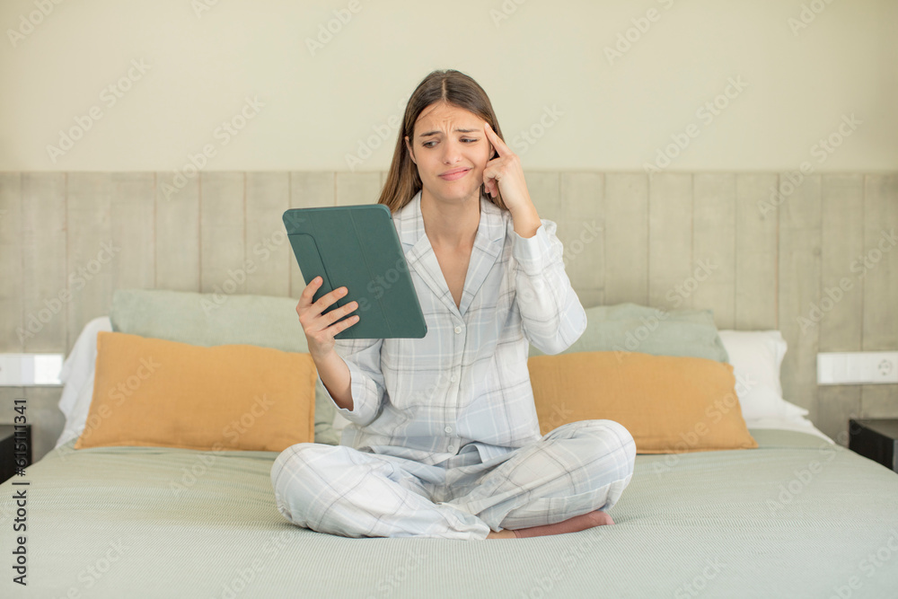young pretty woman looking surprised, realizing a new thought, idea or concept. touchscreen pad concept young pretty woman looking surprised, realizing a new thought, idea or concept. touchscreen pad concept