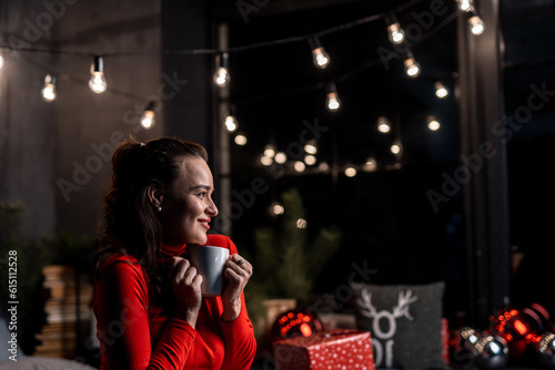 New year celebration portrait. Beautiful lady in red sweater in cozy interior.