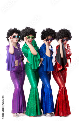 Photography Disco style girls in colorful flared suits and African American wigs on a white background