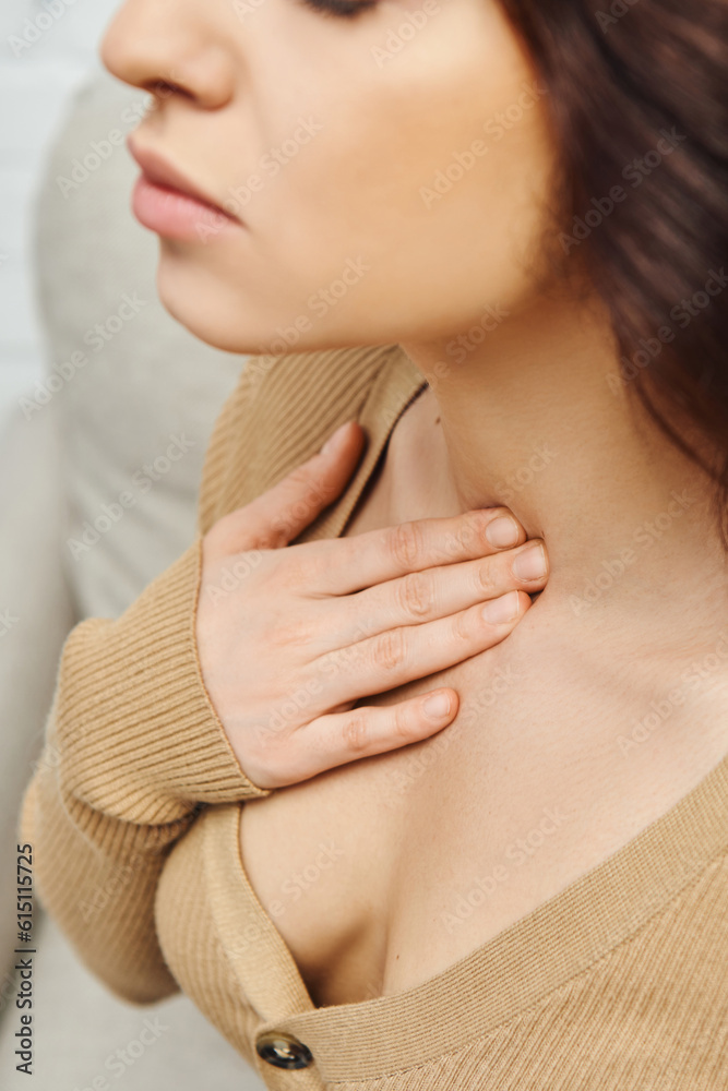 Cropped view of young woman in casual jumper touching neck during self-massage for circulation and lymphatic drainage at home, self-care ritual and holistic wellness practices concept Cropped view of young woman in casual jumper touching neck during self-massage for circulation and lymphatic drainage at home, self-care ritual and holistic wellness practices concept