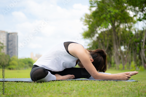 Young female with outdoor activities in the city park, Yoga is her chosen activity. © Wosunan