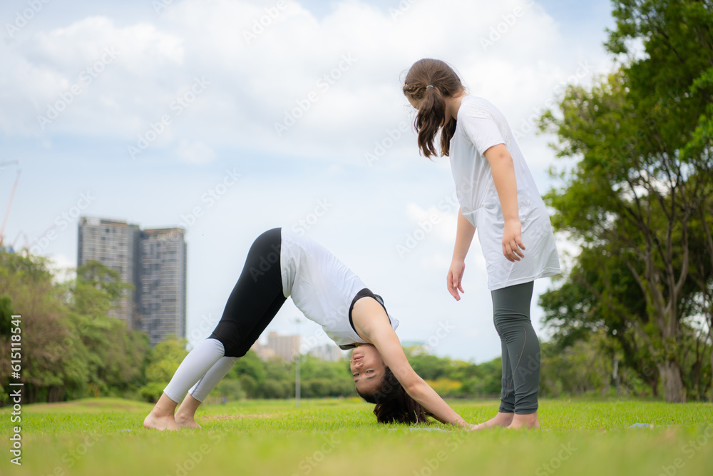 Young female and little girl with outdoor activities in the city park, Yoga is her chosen activity. Young female and little girl with outdoor activities in the city park, Yoga is her chosen activity.