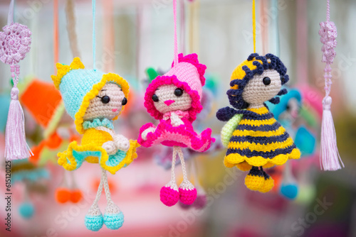 Small funny handmade knitted dolls are for sale at the craft fair.