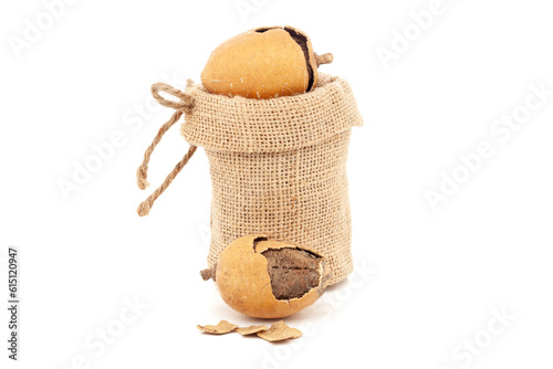 Closeup of Orgnic Hingot or Desert date (Balanites indica) fruits, in a jute bag. Isolated over white background. photo