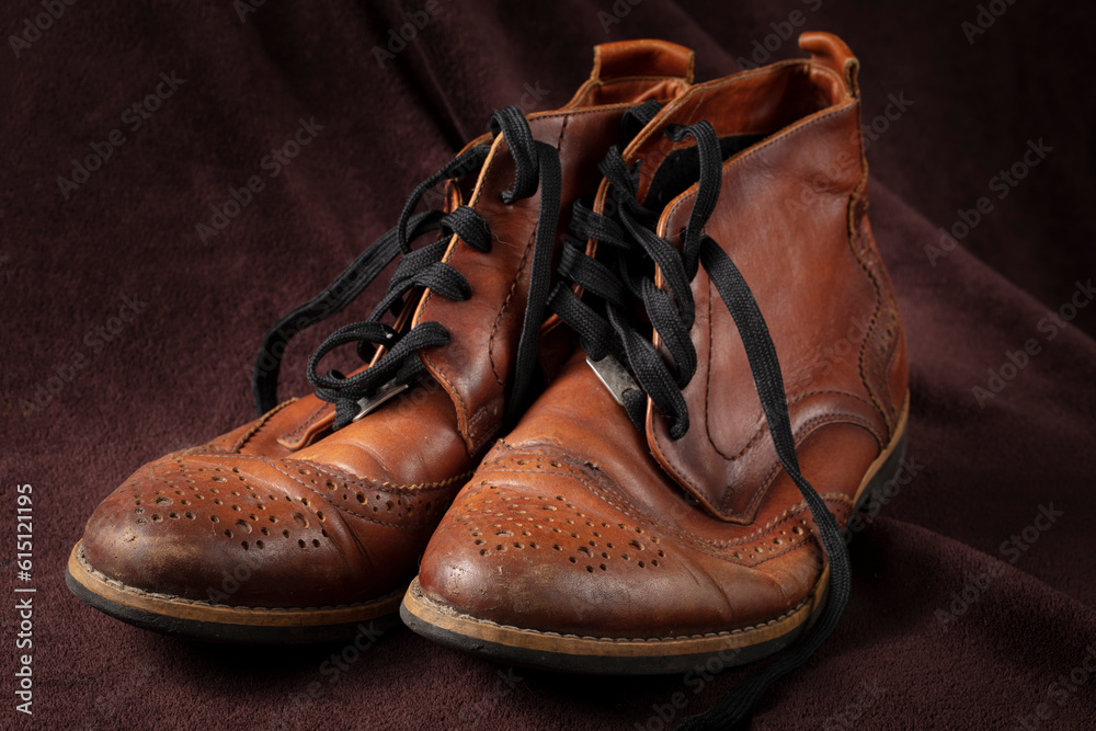 Old leather brown shoes on a dark background. Old leather brown shoes on a dark background.