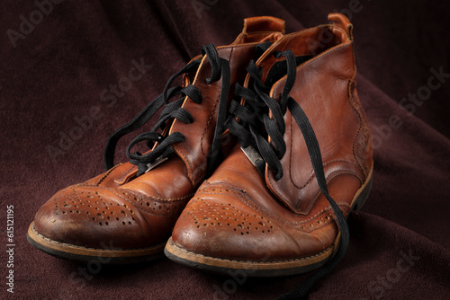 Old leather brown shoes on a dark background.