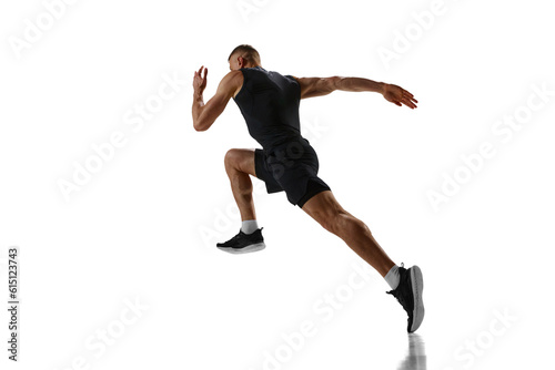 Fototapeta Naklejka Na Ścianę i Meble -  Dynamic image of young man with muscular, strong, fit body, professional runner in motion, training against white studio background